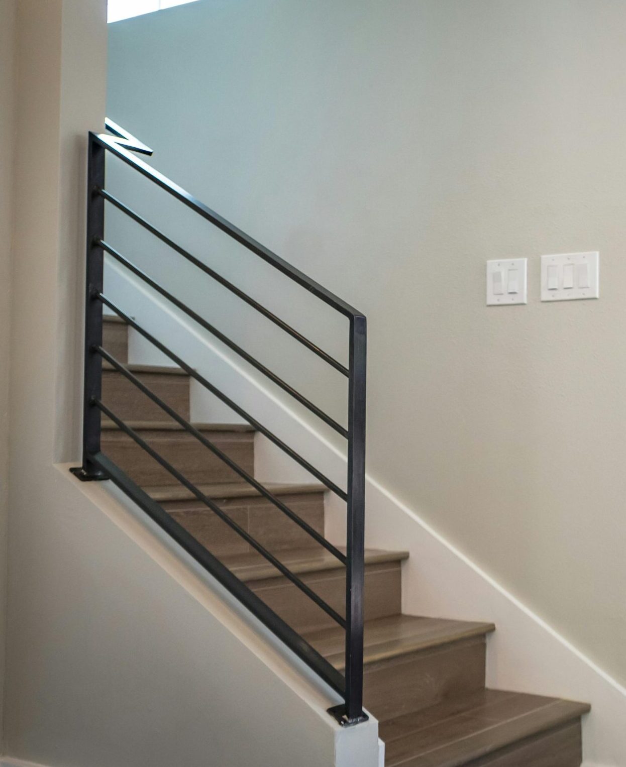 Contemporary interior with a vibrant red entrance door and stairs, showcasing minimalist design.